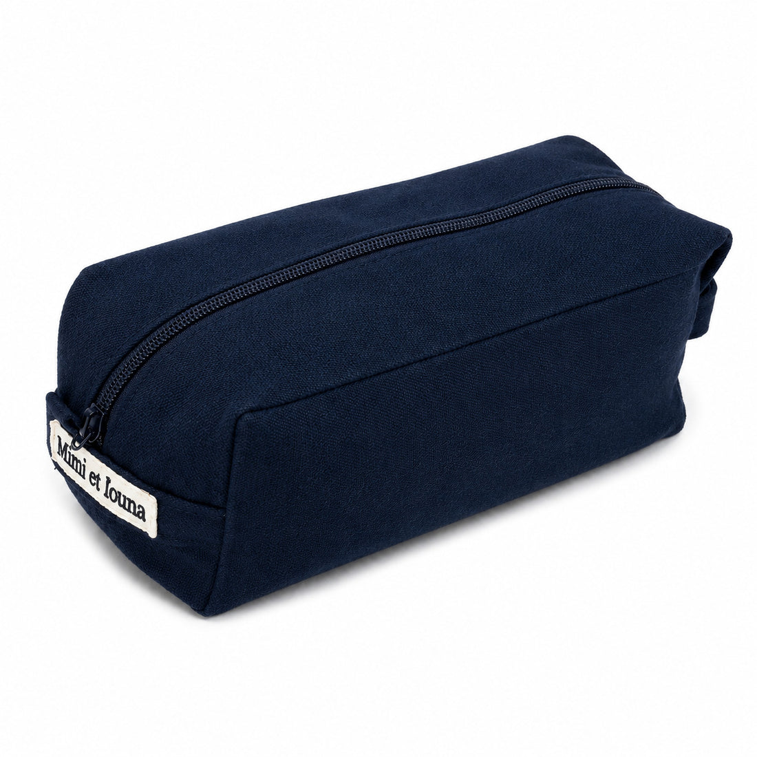 A navy blue canvas zippered pouch with a white fabric label on the side that reads 'Moi et Iona', photographed on a clean white background.